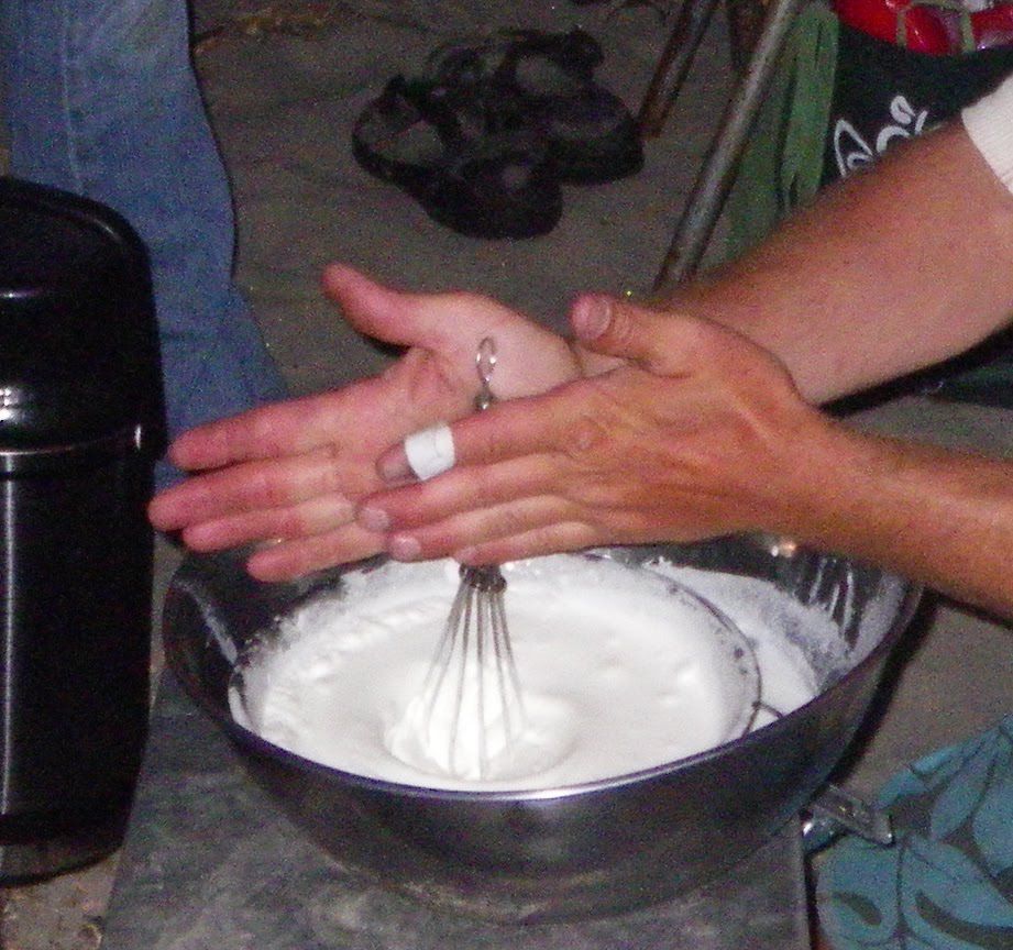 A person is mixing something in a bowl with a whisk