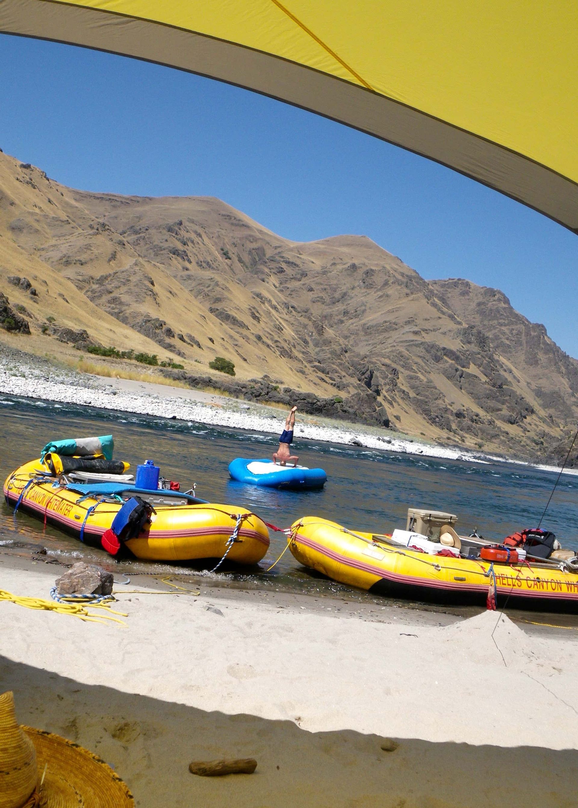 A couple of rafts on a beach with mountains in the background