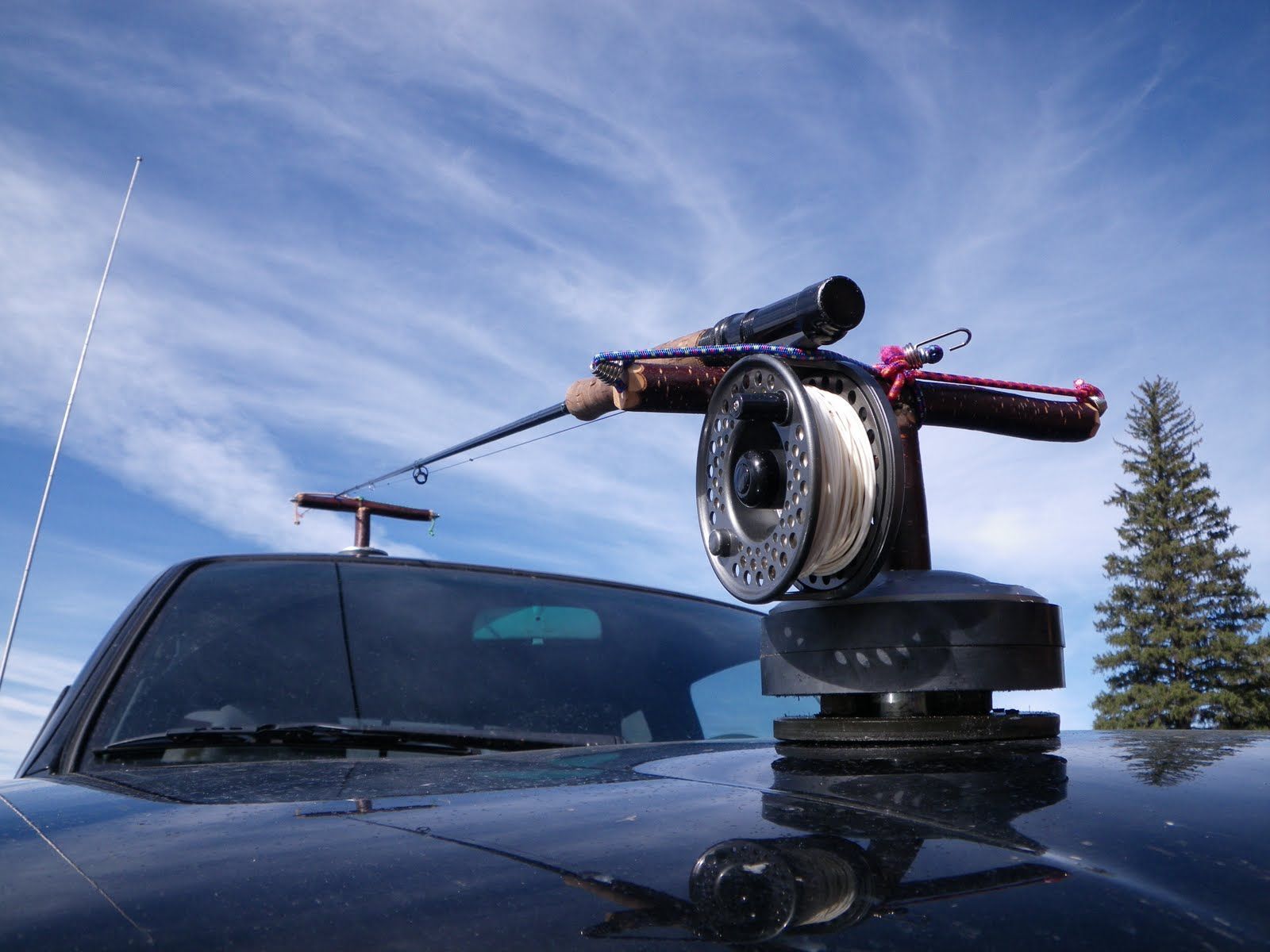 A fishing rod is attached to the roof of a truck