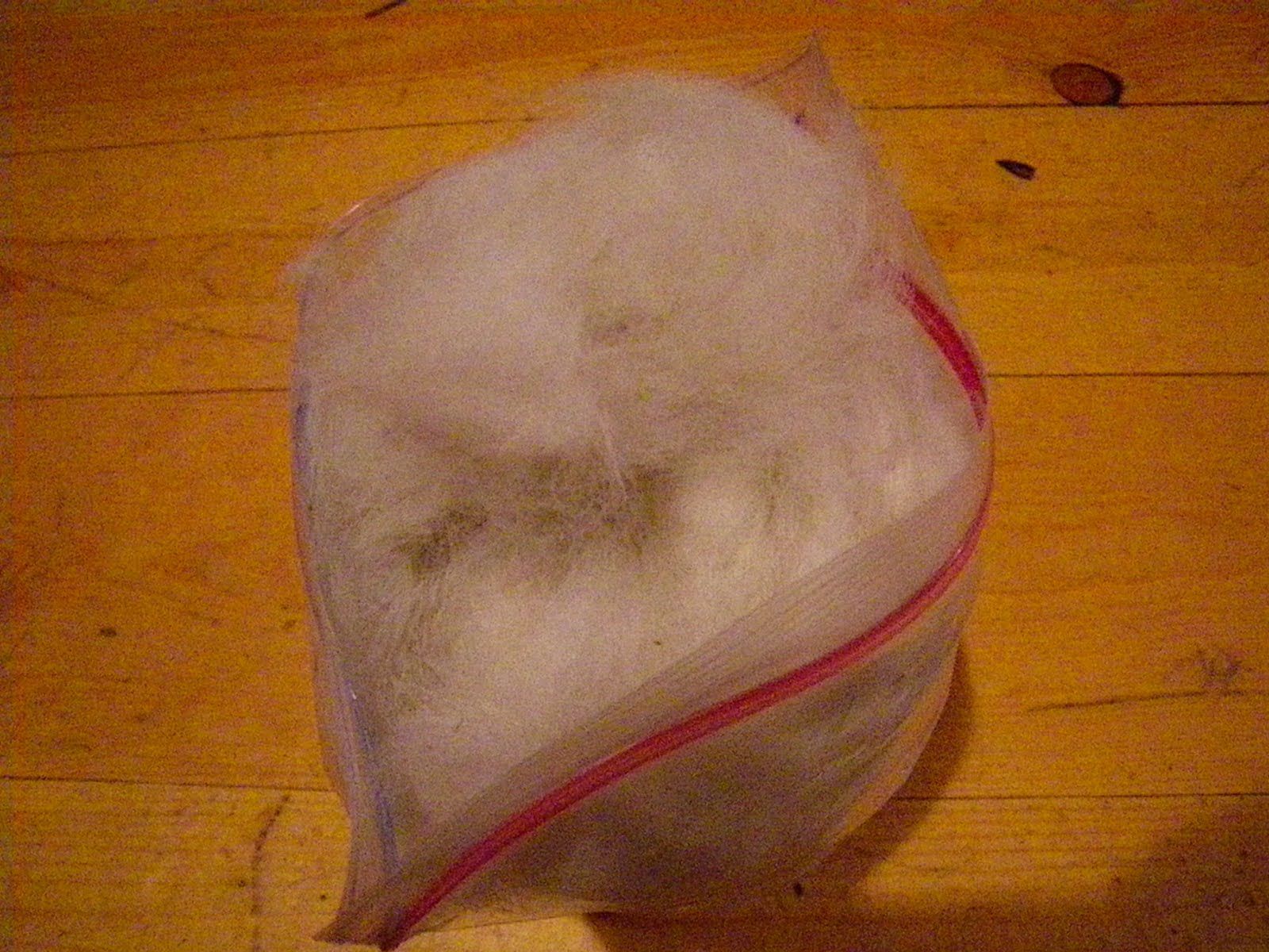 A bag of ice is sitting on a wooden table.