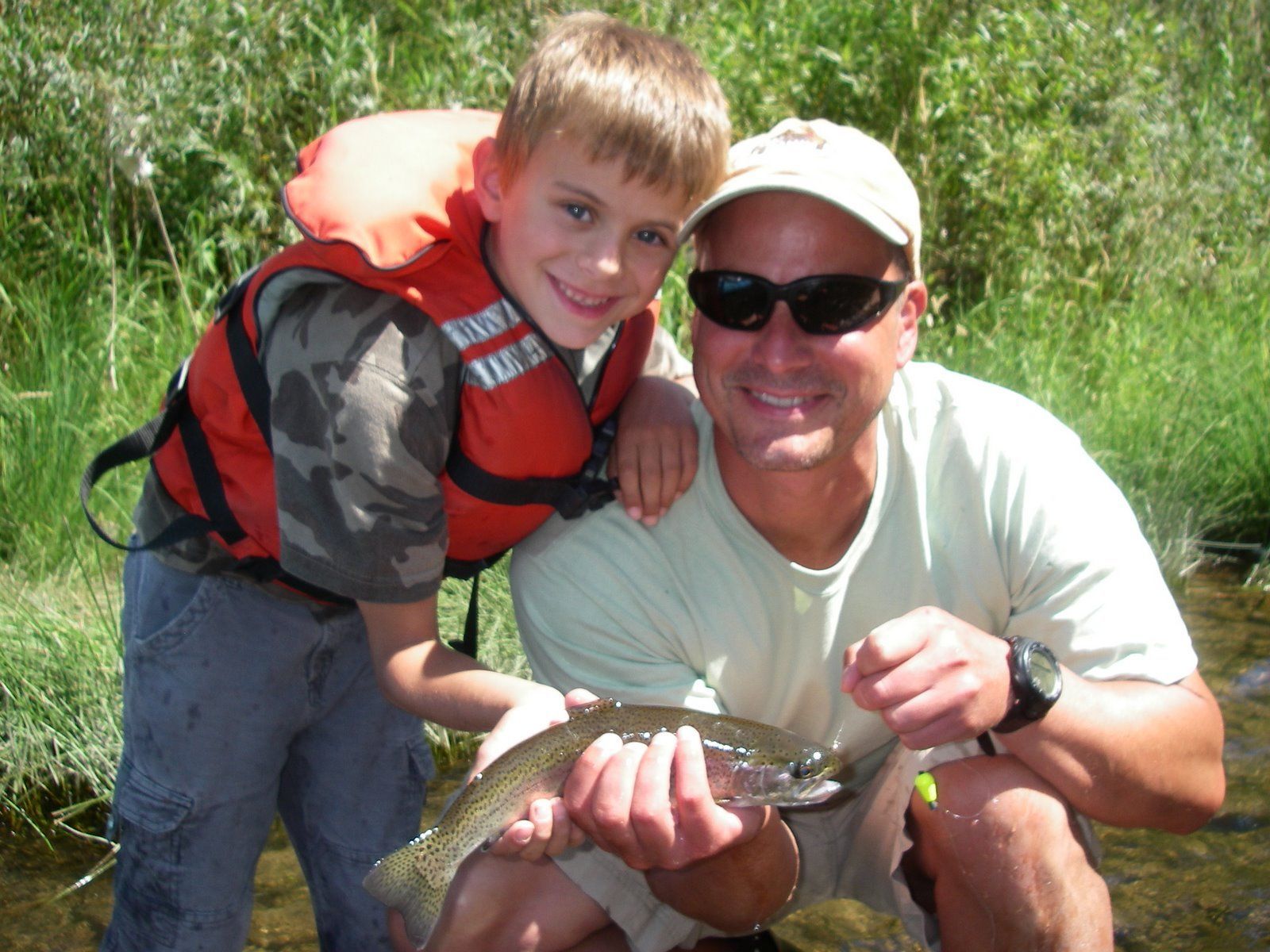 A Man and A Boy Are Holding a Fish in Their Hands