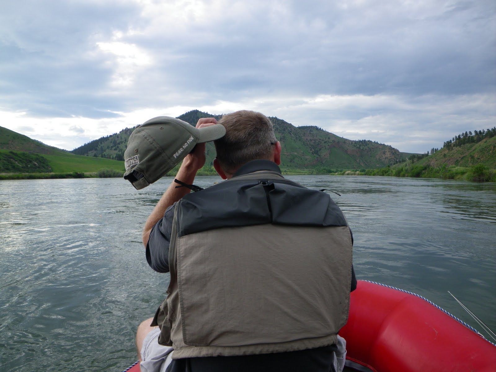 A man in a raft with mountains in the background