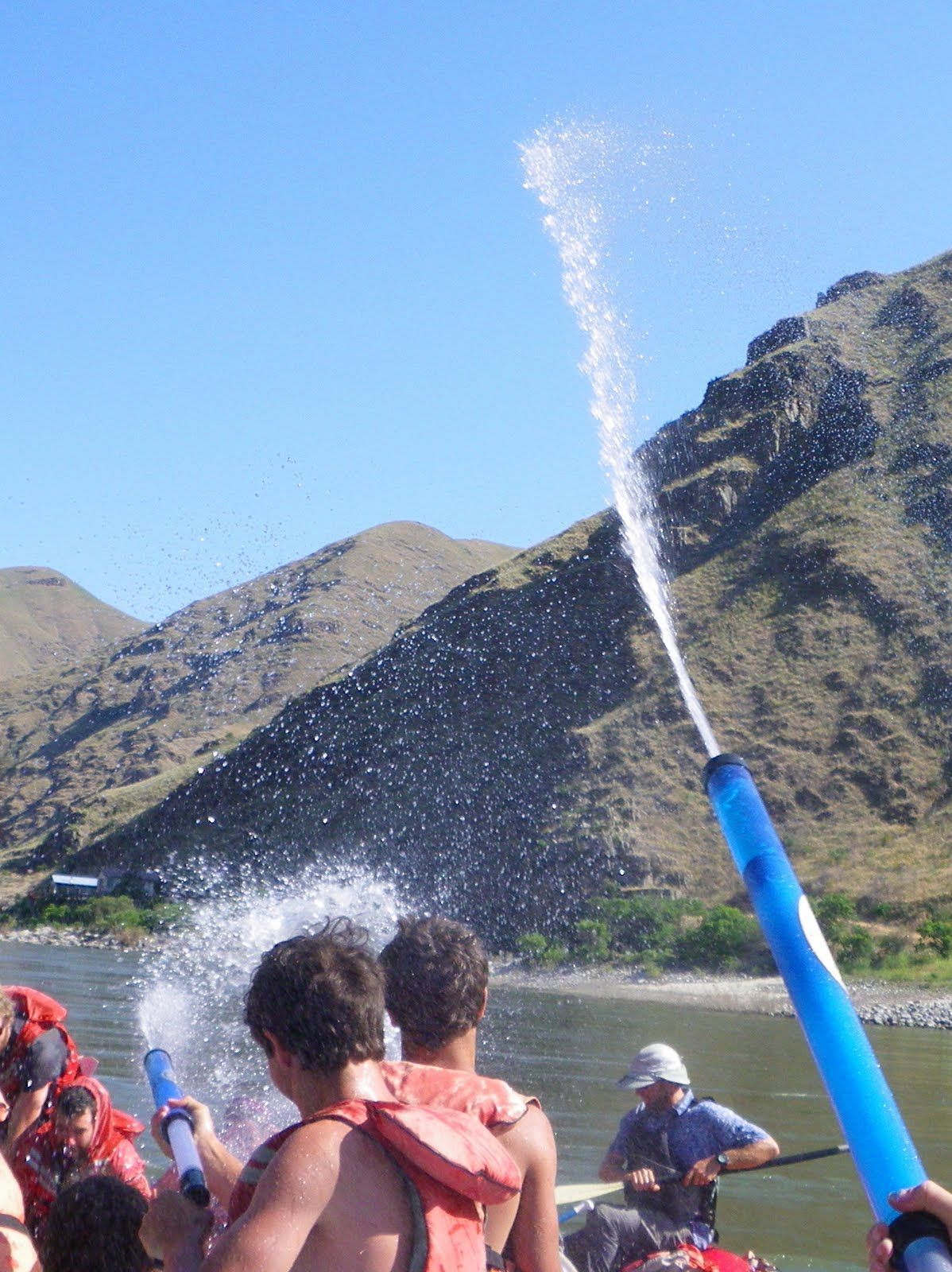 A group of people in a boat spraying water at each other