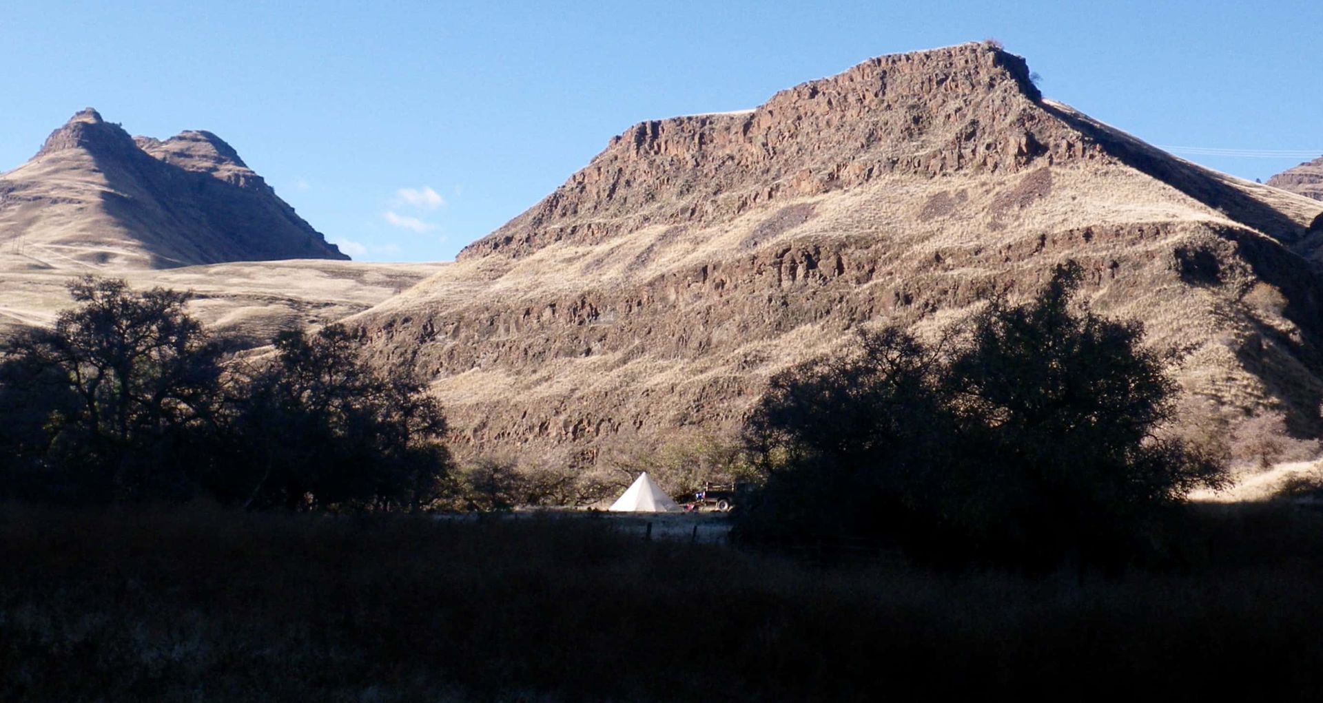 Tent in the Middle of A Desert with Mountains in The Background