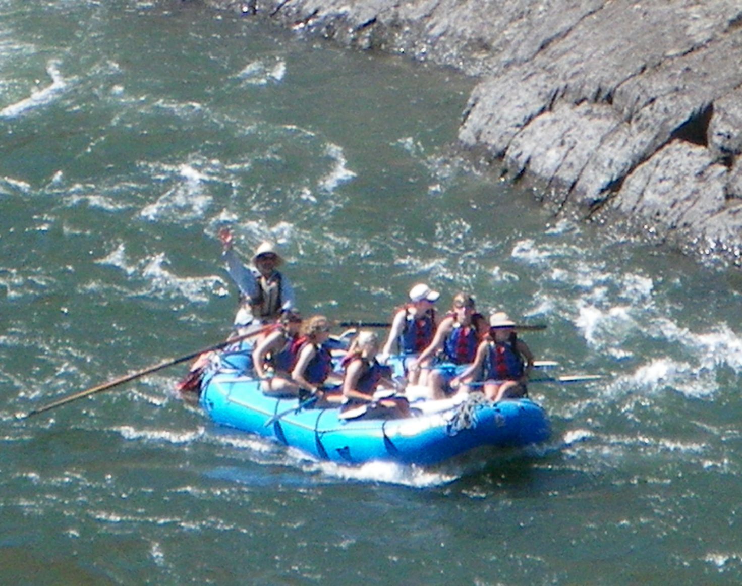 A group of people in a blue raft with the number 80 on it