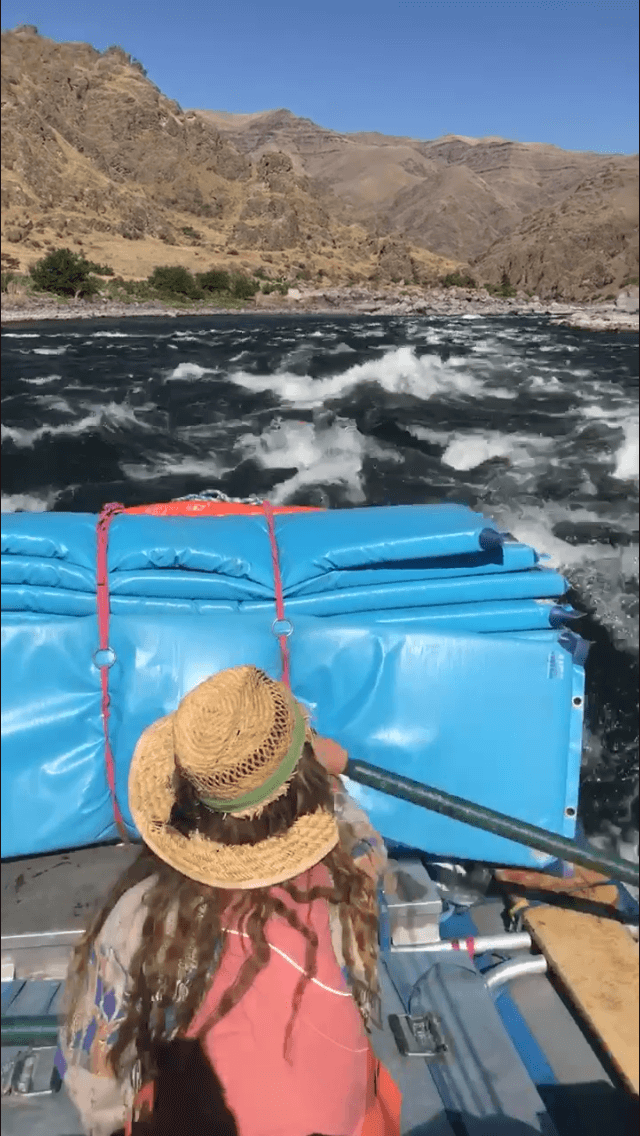 Woman in A Straw Hat Is Rowing a Boat in The Water