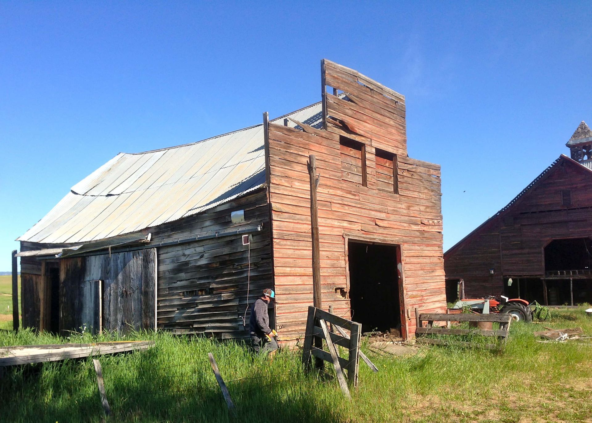 A man is standing in front of an old wooden building