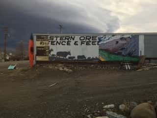 A large billboard on the side of a building advertising western ore fence and feed.