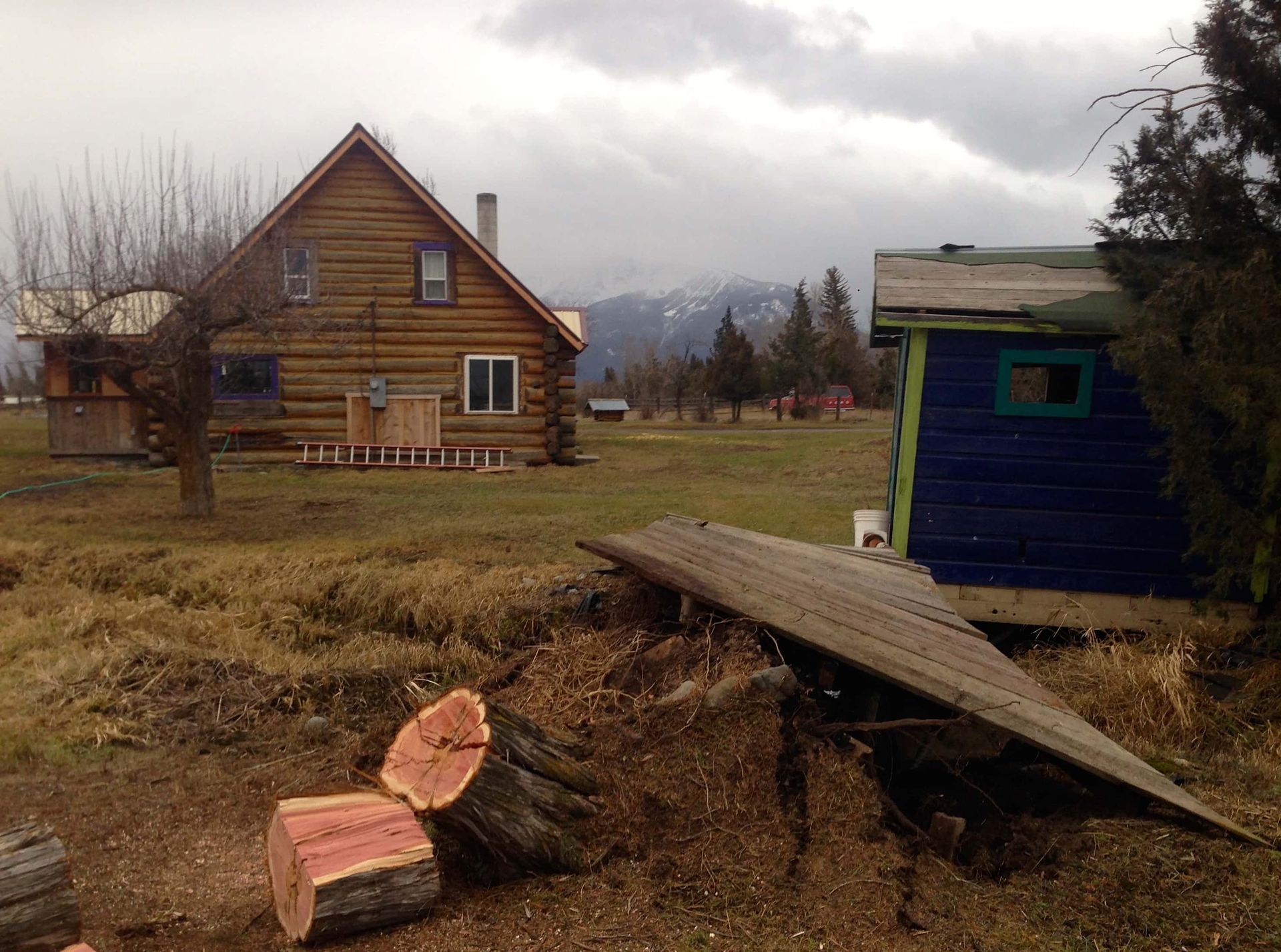 A log cabin sits in the middle of a grassy field