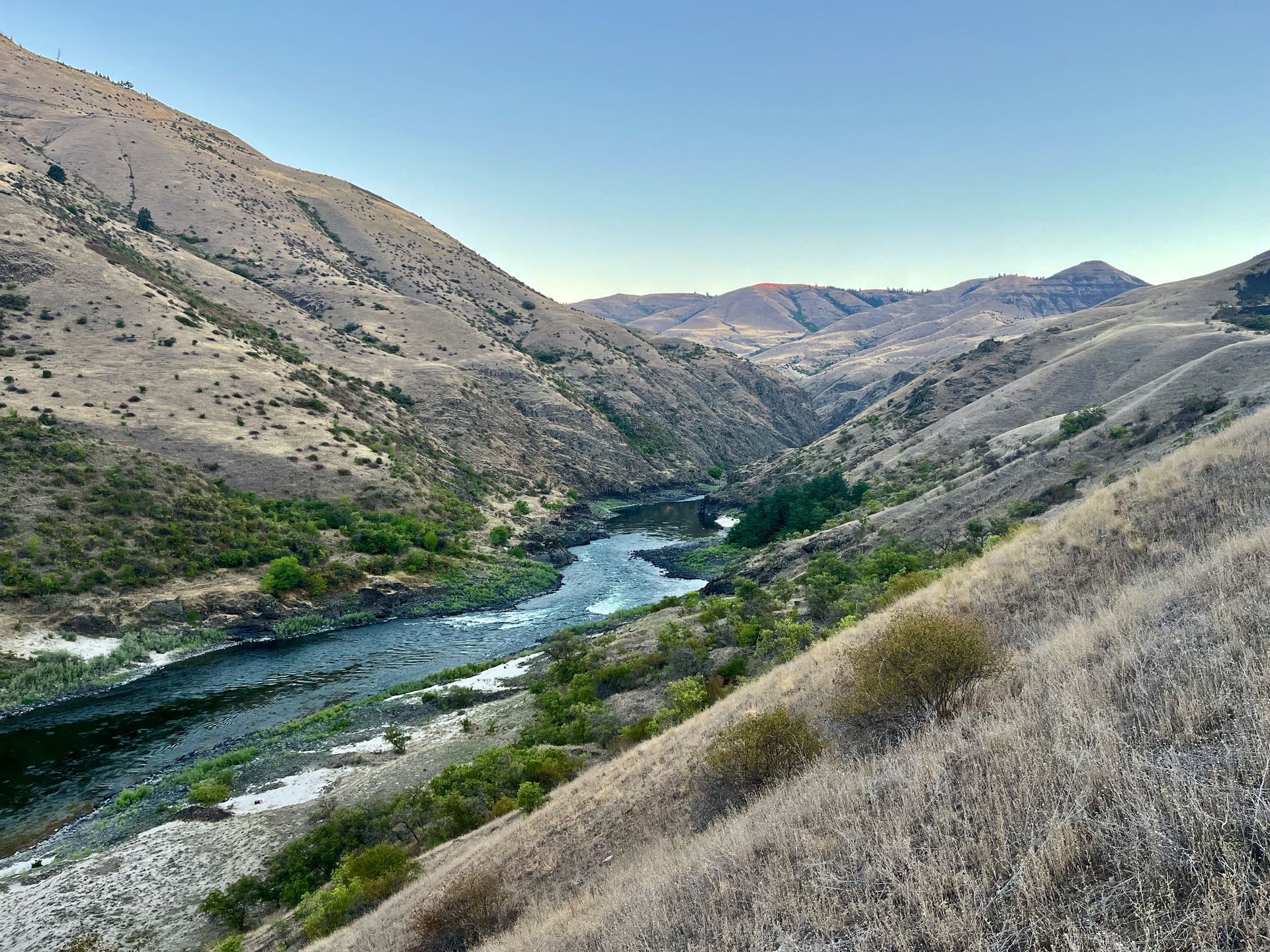 A Person in A Blue Raft Is Floating Down a River