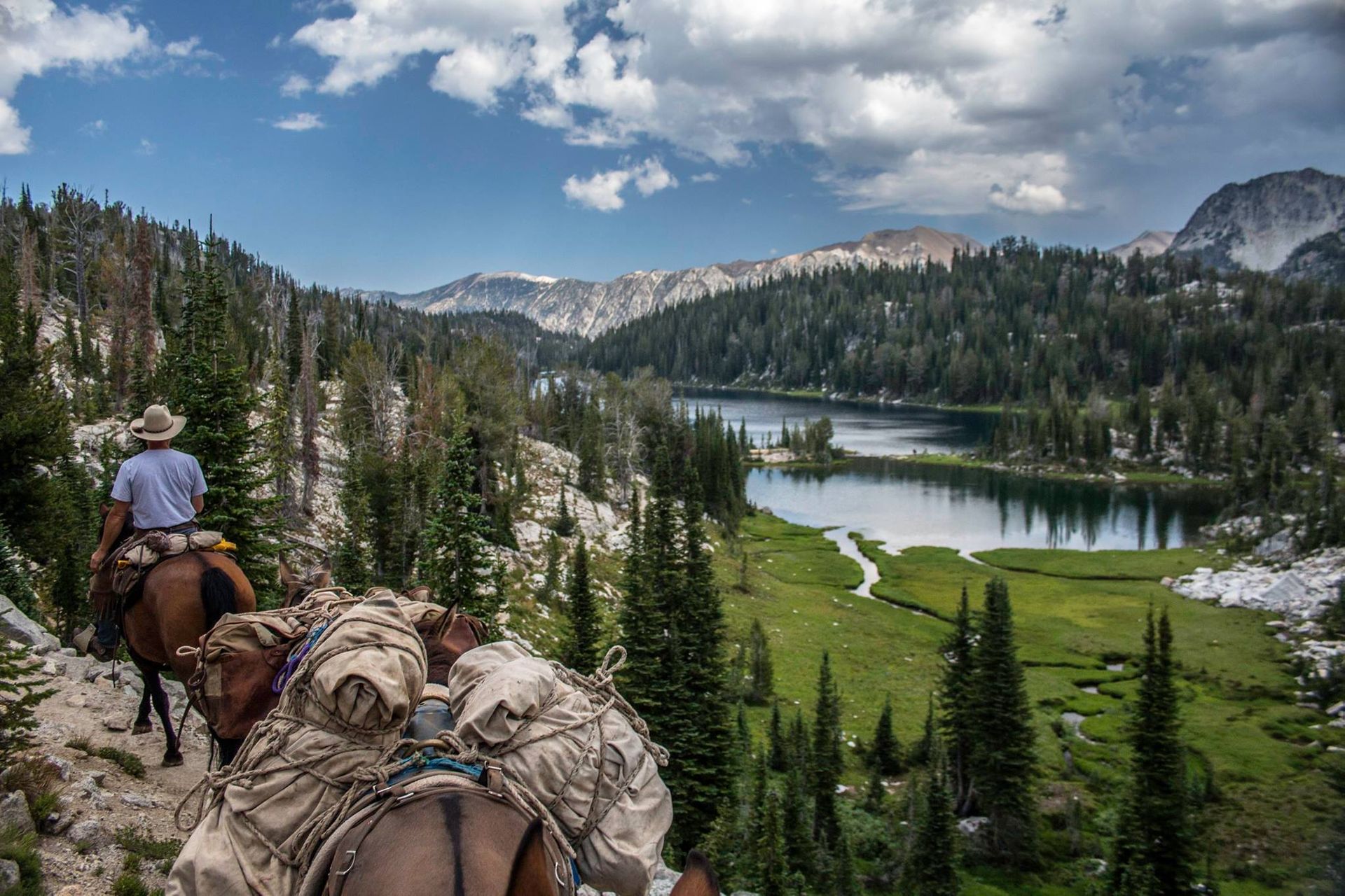Man Riding a Horse in The Mountains Near a River