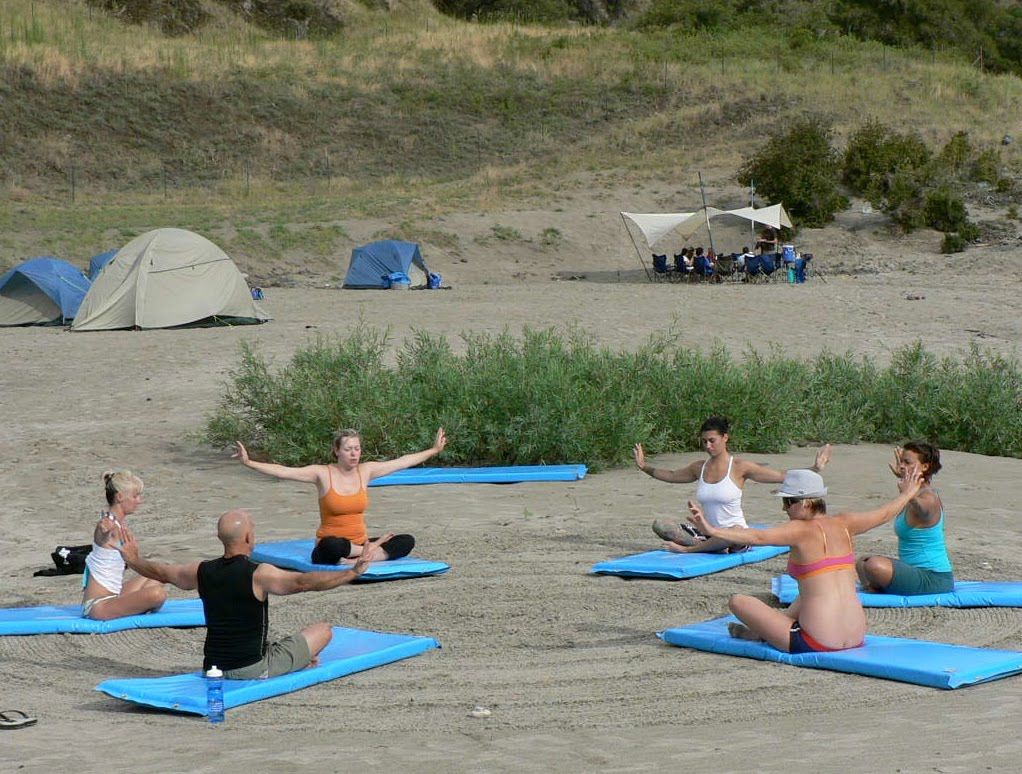 A group of people are doing yoga on the beach