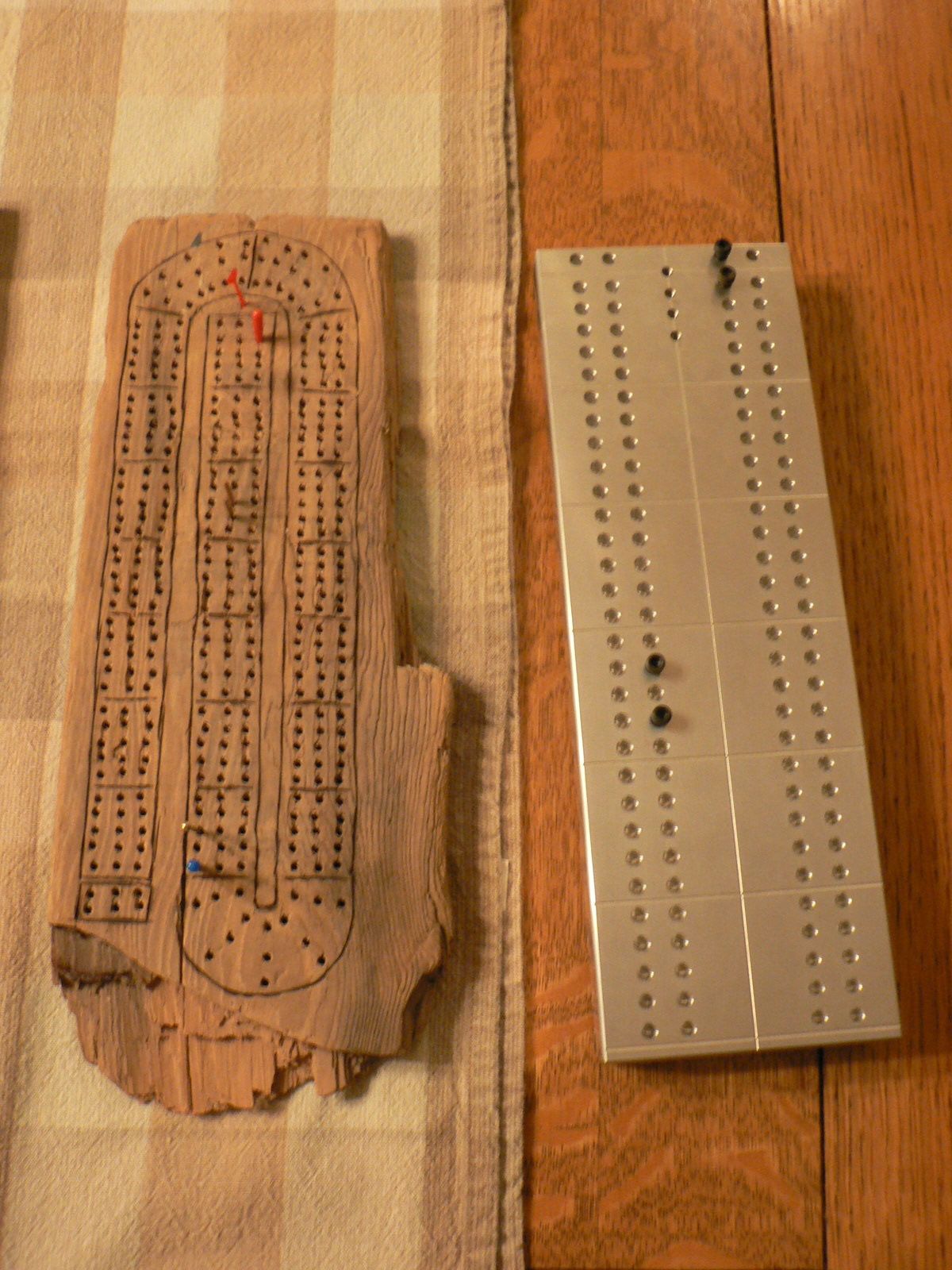 Two cribbage boards are on a wooden table