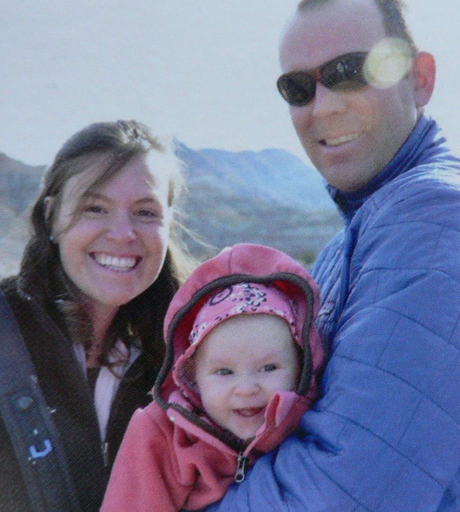 A man and woman are holding a baby in their arms
