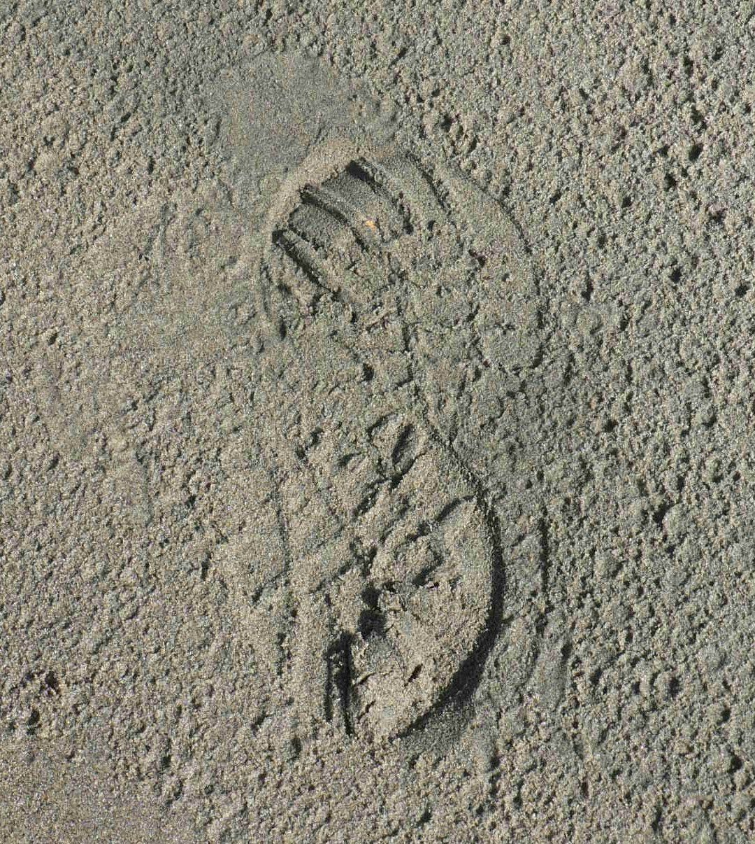 A close up of a footprint in the sand.