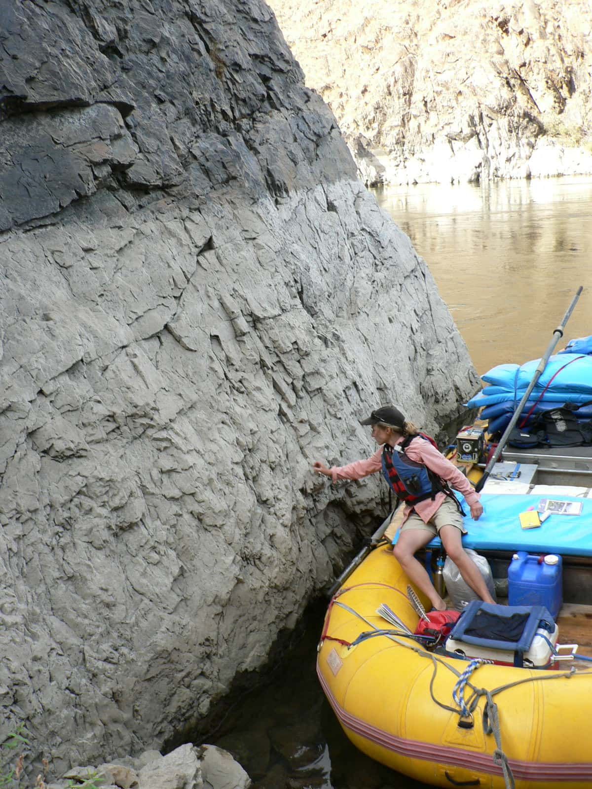 A Person in A Yellow Raft Is Climbing a Rock