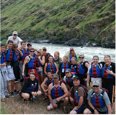 A group of people posing for a picture in front of a river