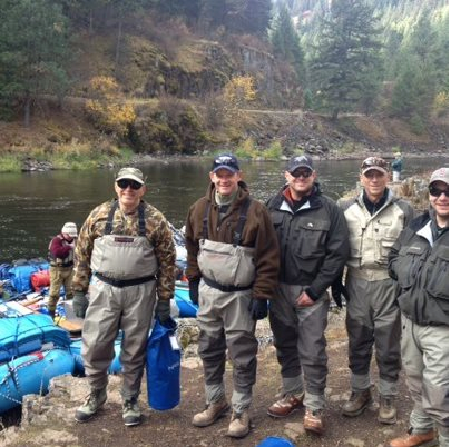 A group of men are posing for a picture in front of a river