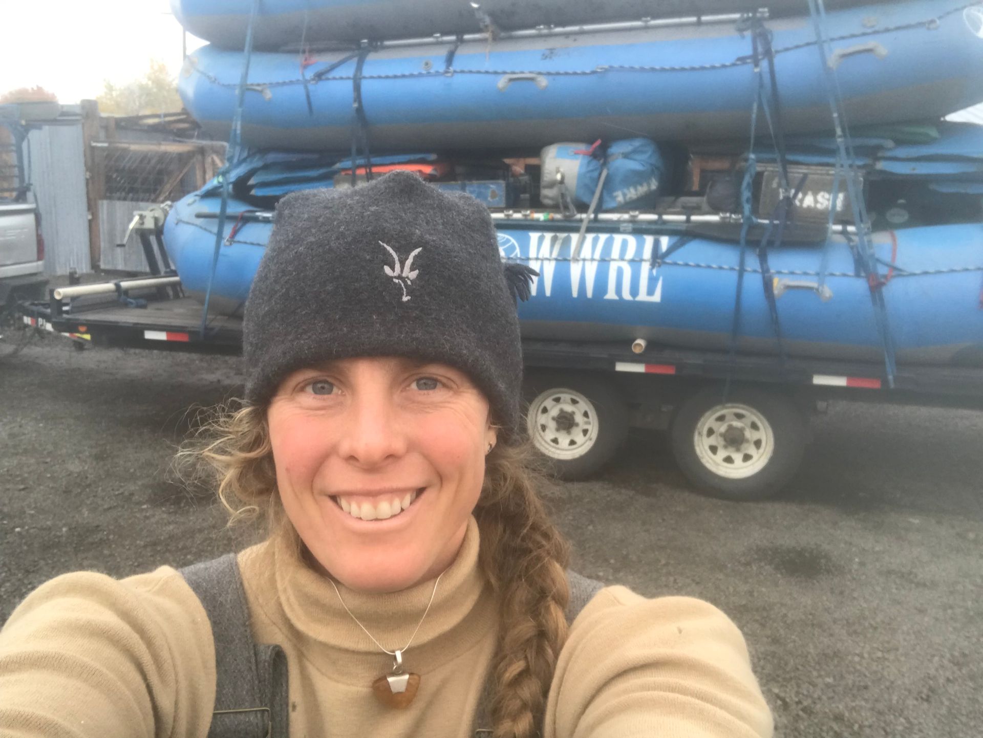 A person smiling in front of whitewater rafts