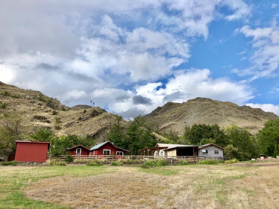 A Group of Houses Sitting on Top of A Hill in the Middle of A Field