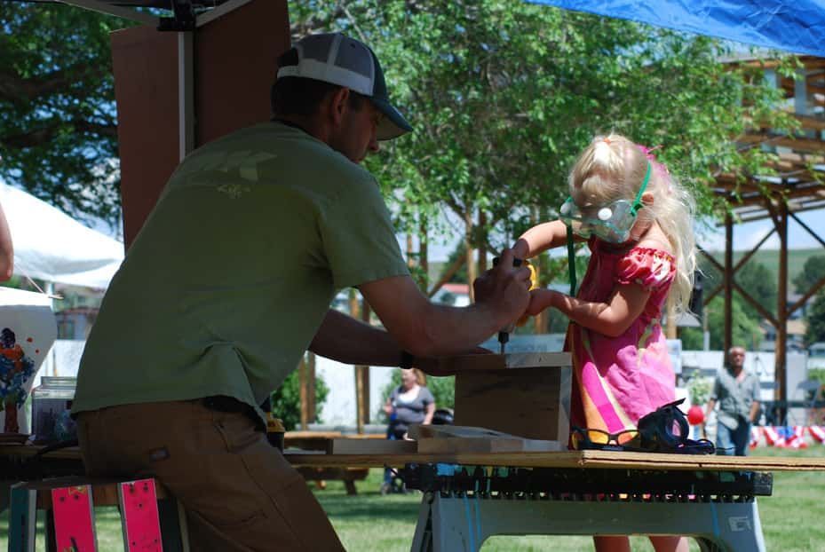 Man and A Little Girl Are Working on A Wooden Table