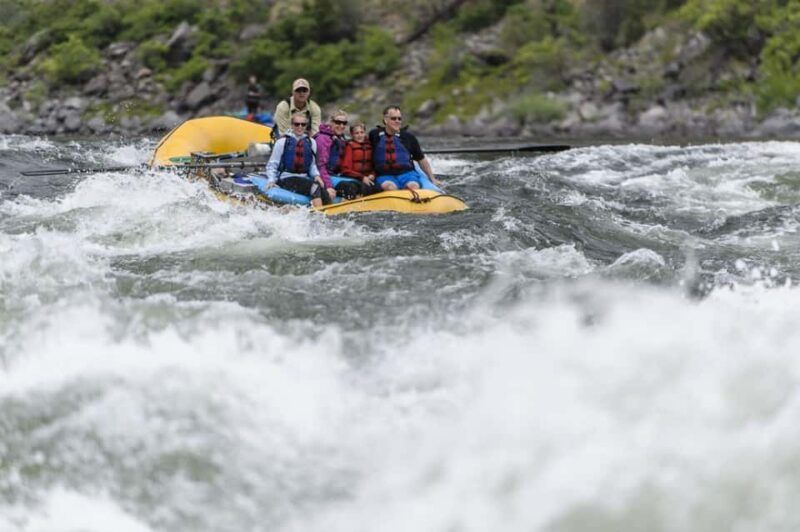 Group of People Rafting Down a River on Yellow Raft