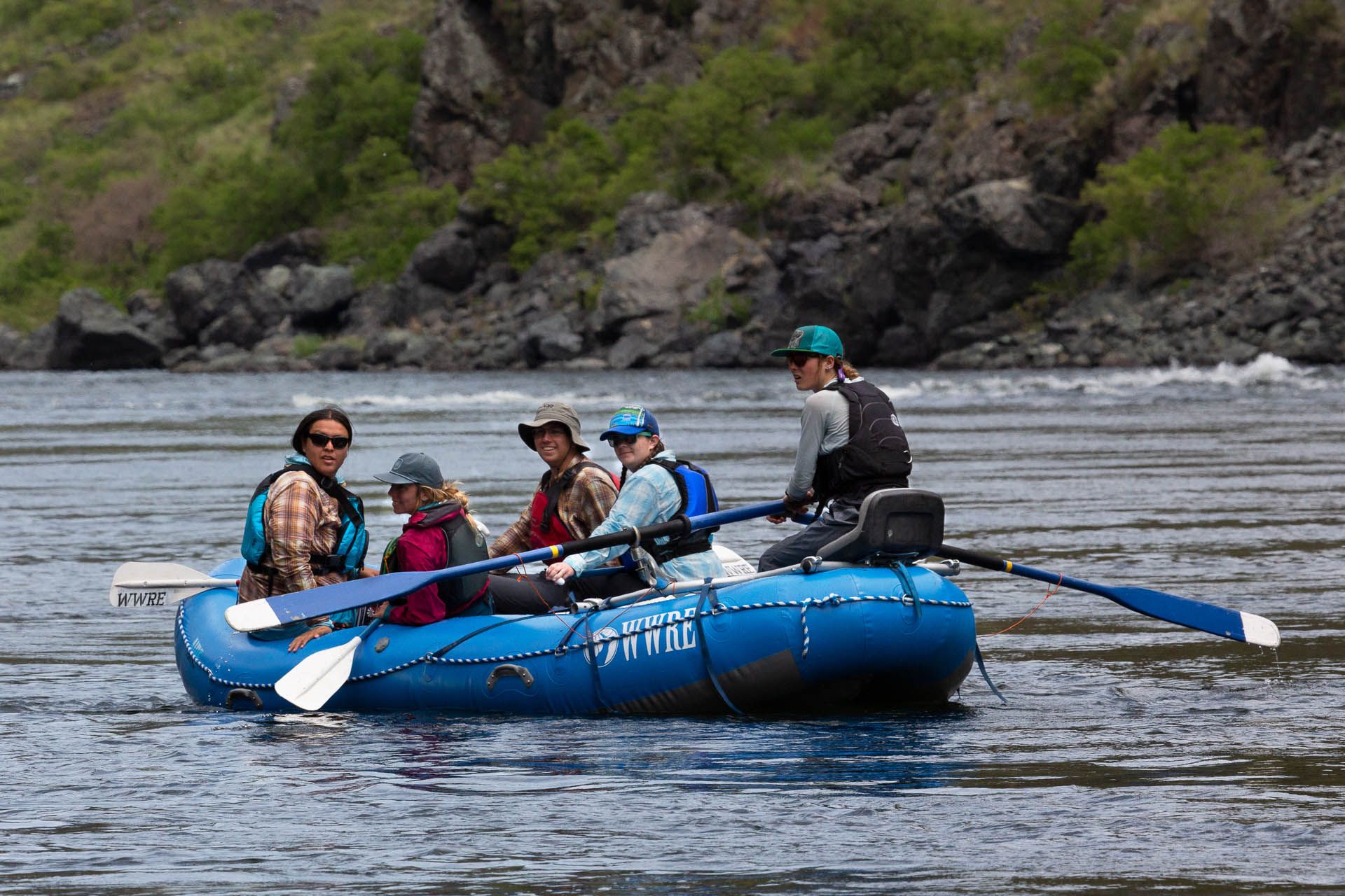 A group of people are rowing a raft down a river.