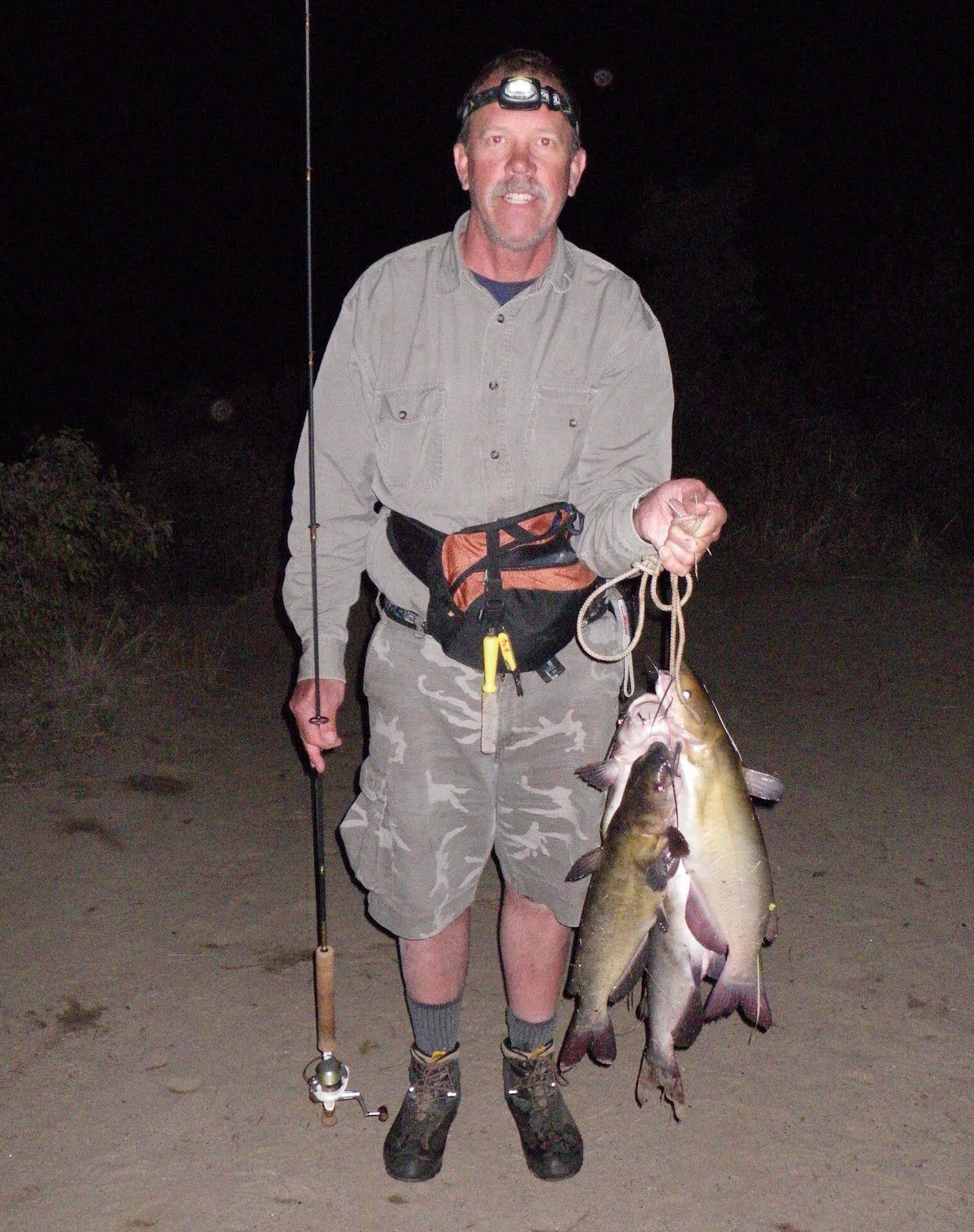 A man holding a fishing rod and a bunch of fish