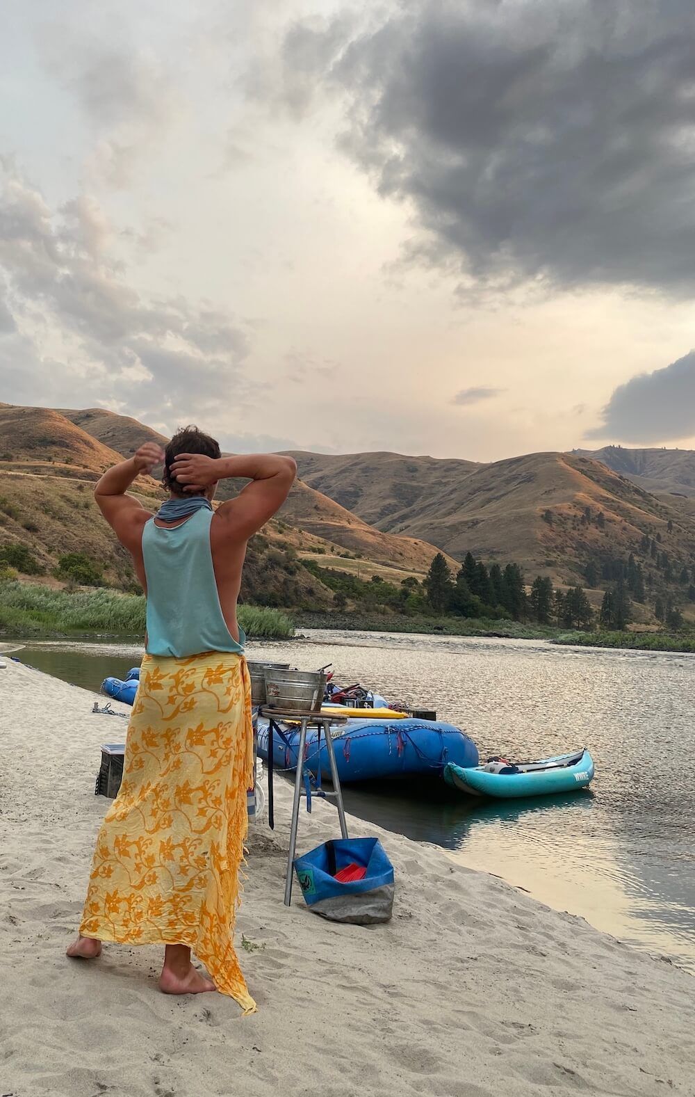 Person in A Yellow Skirt Is Standing on A Beach Next to A River