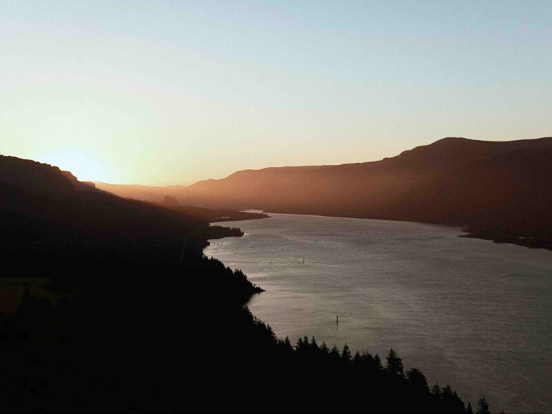 An Aerial View of A River Surrounded by Mountains at Sunset