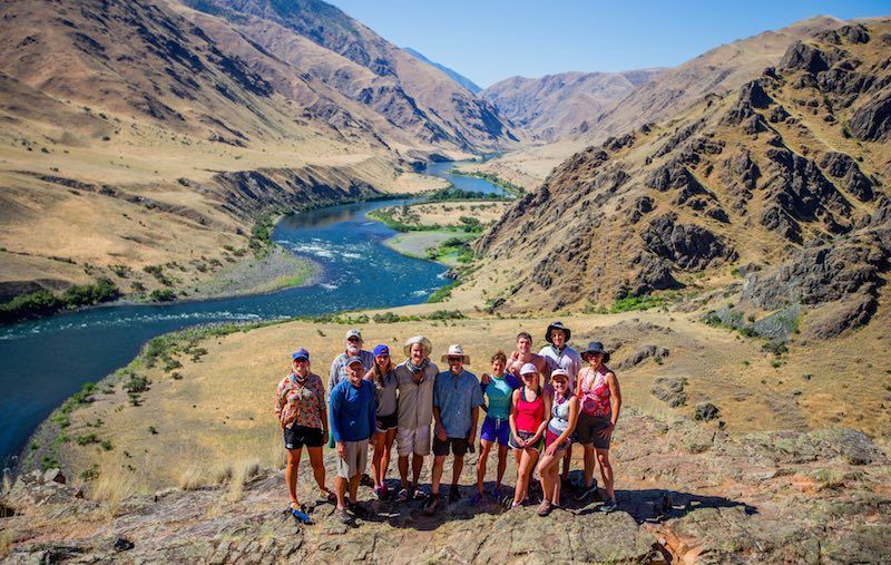 A Group of People Are Posing for A Picture on Top of A Mountain
