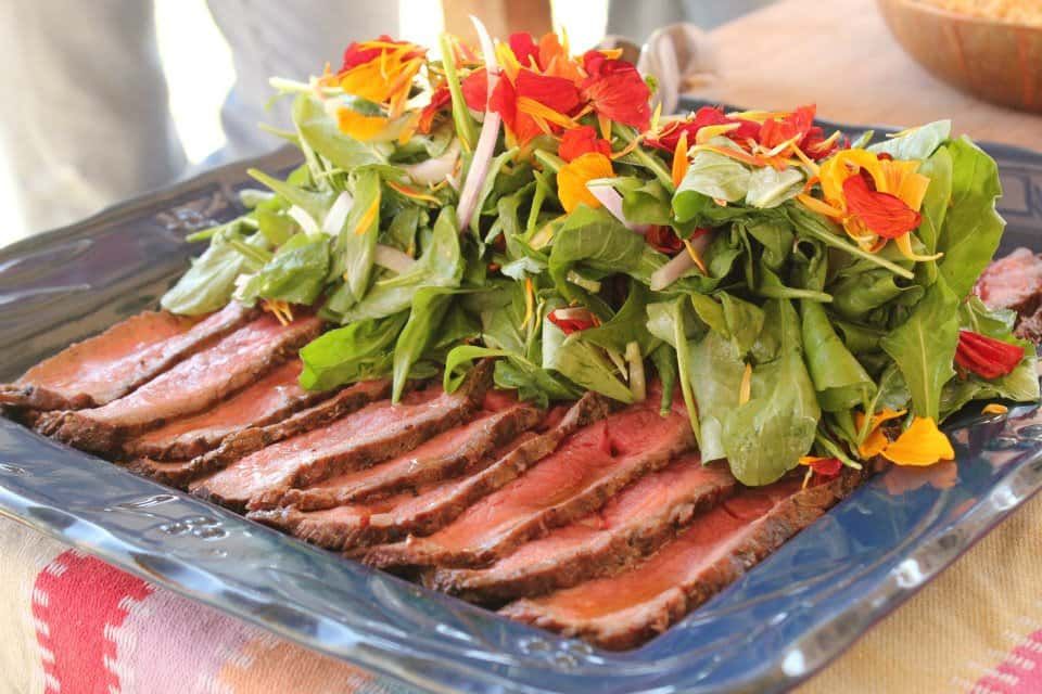 Close up of a plate of food with meat and vegetables on a table