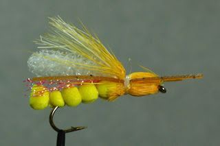A close up of a yellow fly on a hook.