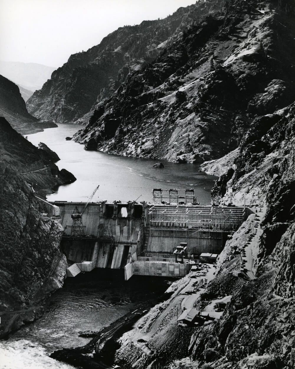 A Black and White Photo of A River Surrounded by Mountains