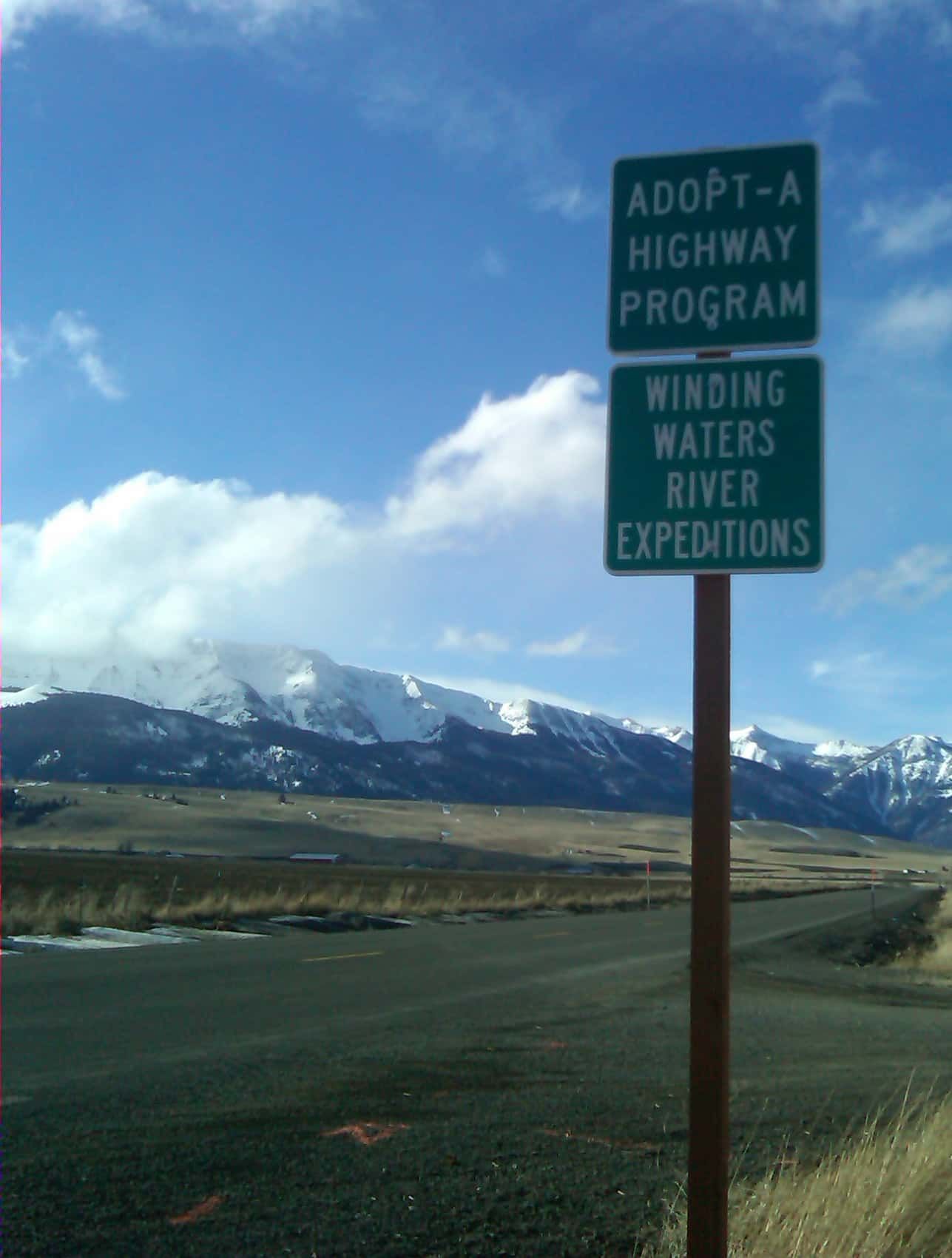Sign that Says Adopt a Highway Program Winding Waters River Expeditions