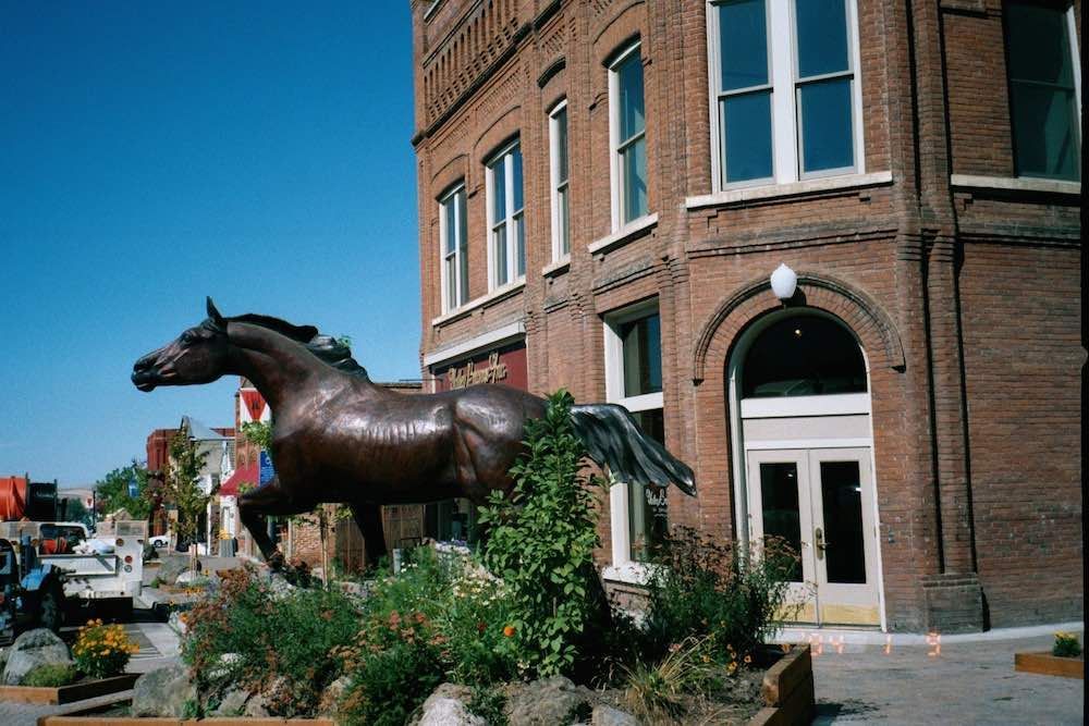 Statue of A Horse in Front of A Brick Building
