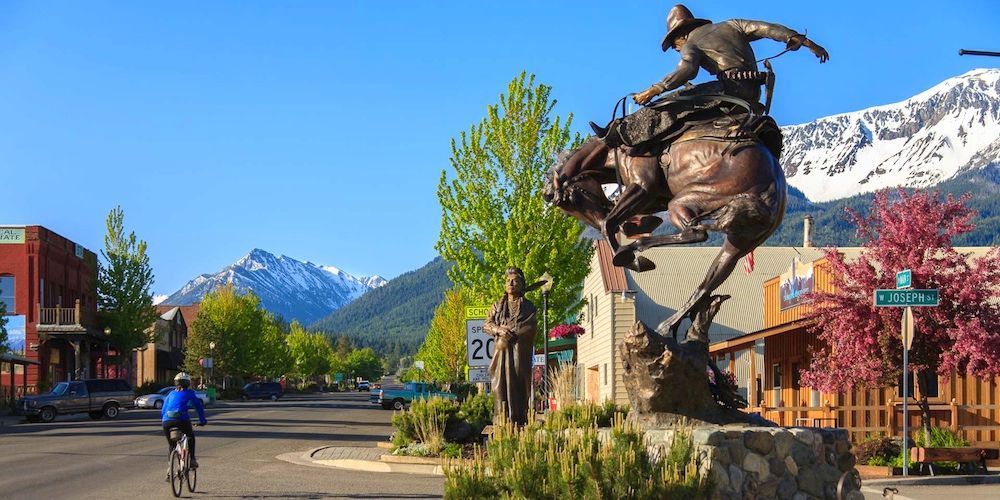 A statue of a man riding a horse in a small town.