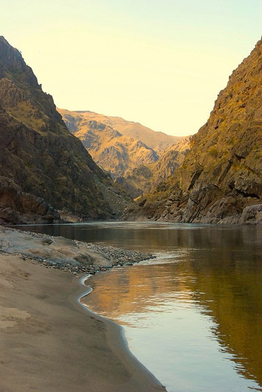River Flowing Through a Canyon with Mountains in The Background