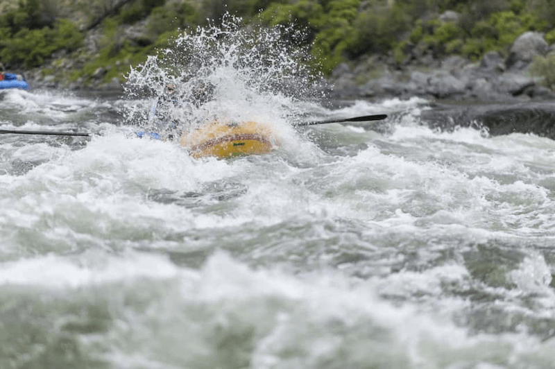 A person is rowing a raft down a river.