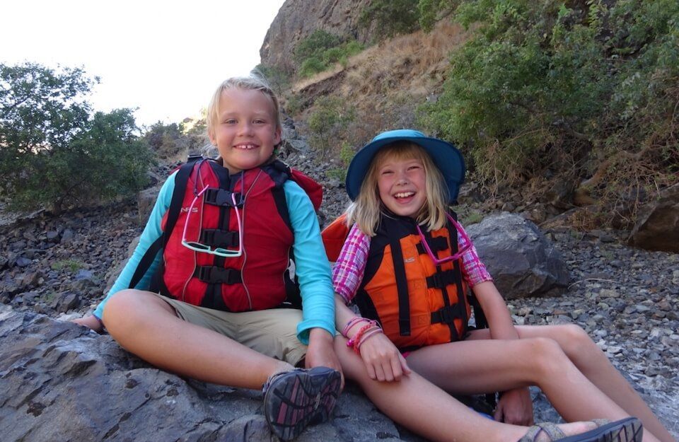 Two smiling kids wearing life vests