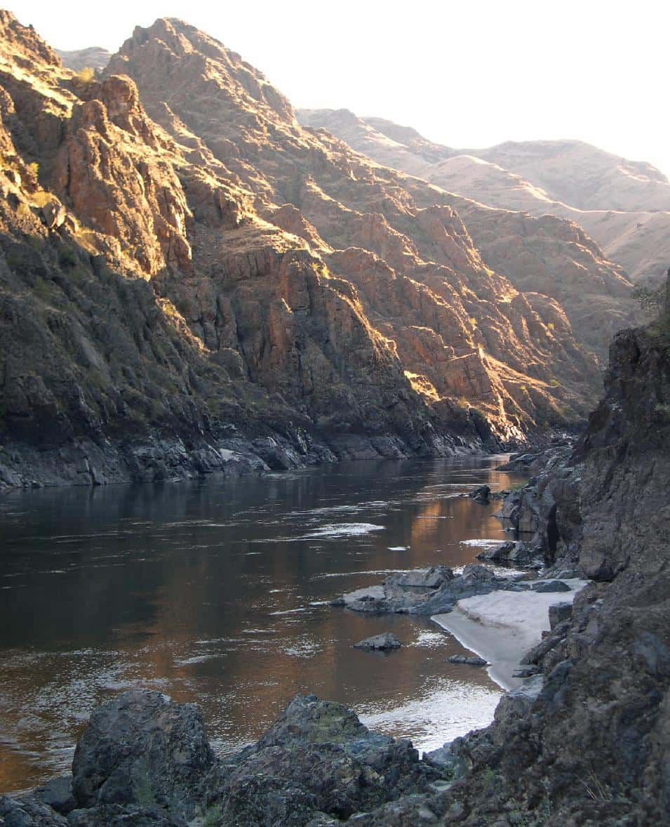 River Flowing Through a Canyon with Mountains in The Background