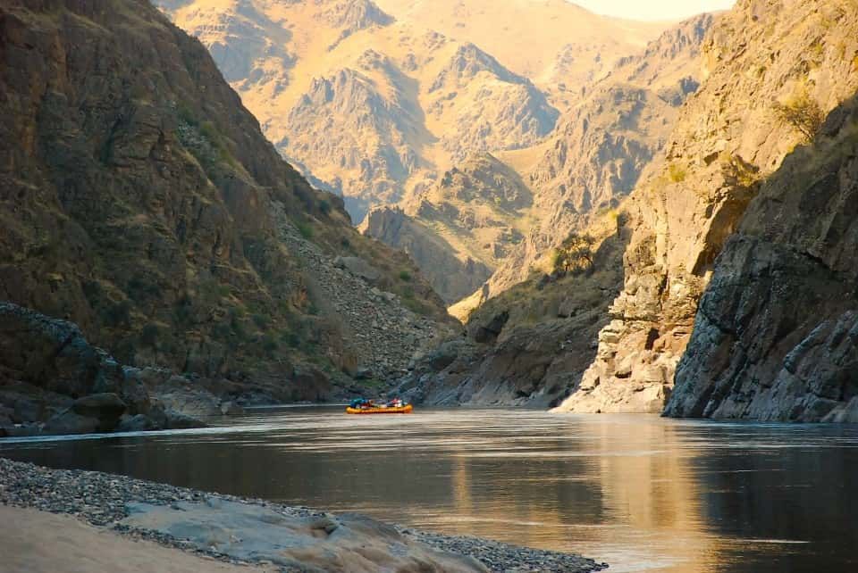 Boat Floating Down a River in The Middle of A Canyon.