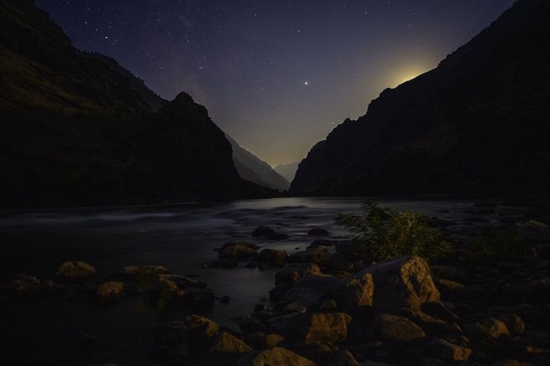 Moon Shining Over a River in The Mountains at Night