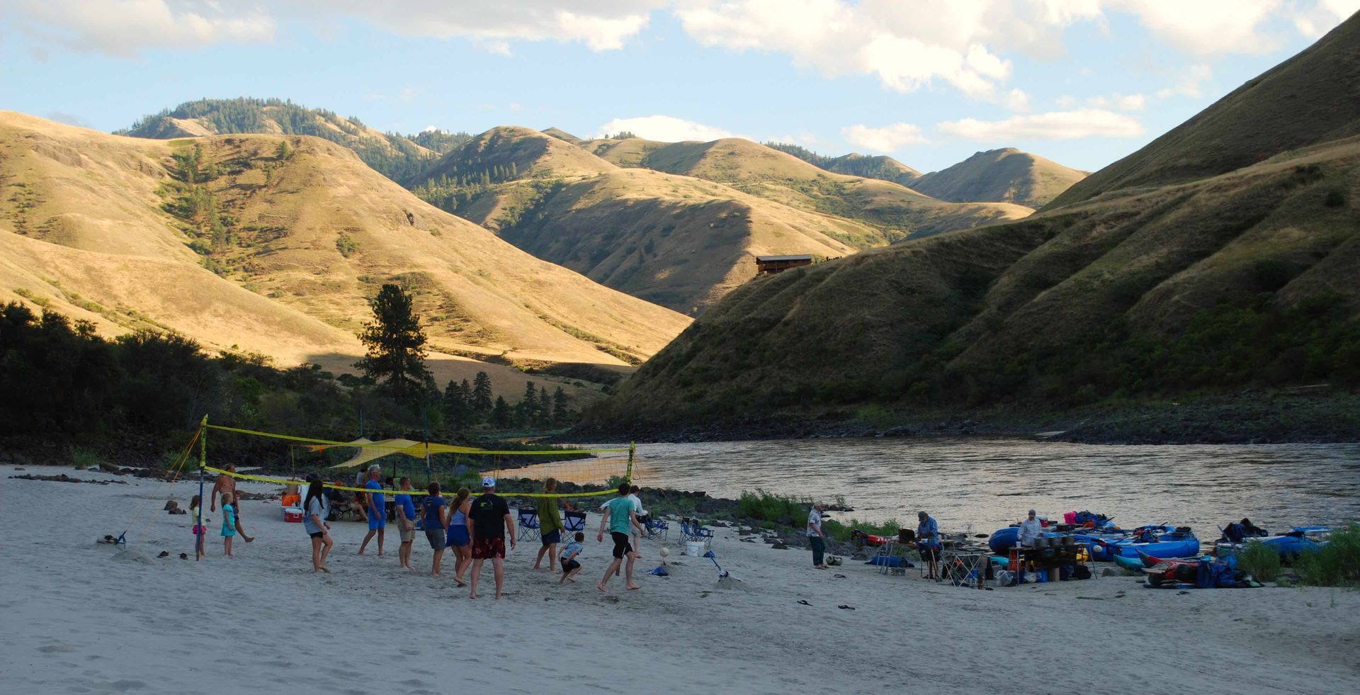 Group of People Standing on A Beach with Mountains in the Background