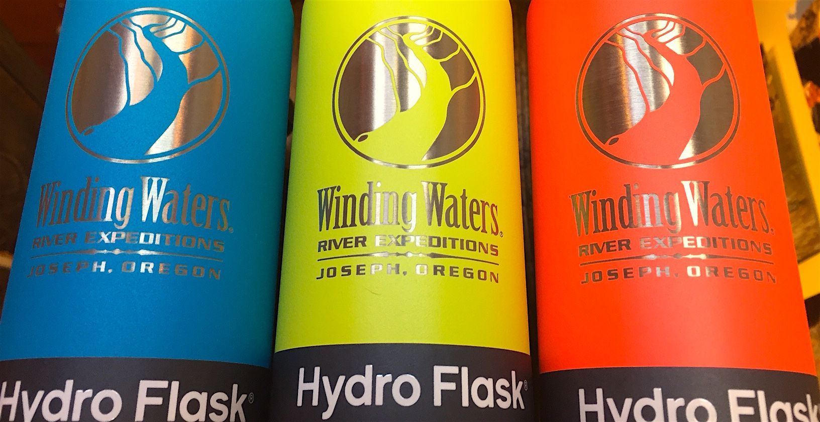 Three hydro flasks are lined up next to each other
