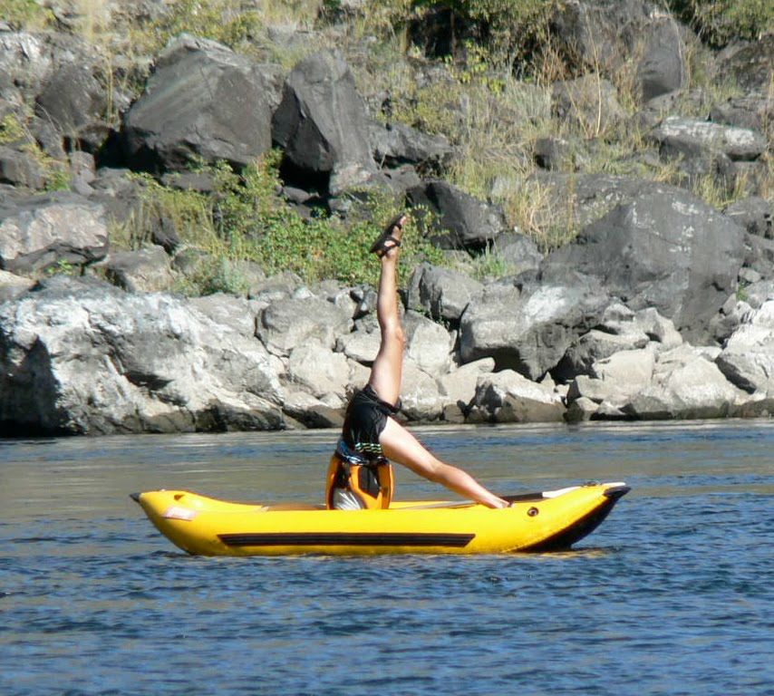A person is doing a yoga pose in a yellow kayak