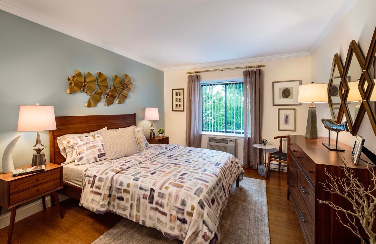 Cozy bedroom with a queen bed, two wooden nightstands, and a dresser.