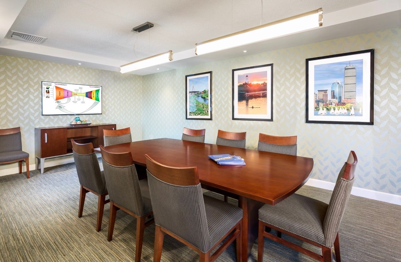 Communal meeting room with a large wooden table, chairs, and framed wall art.