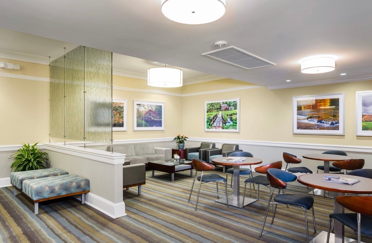 Interior community lounge with seating area and framed art on beige walls