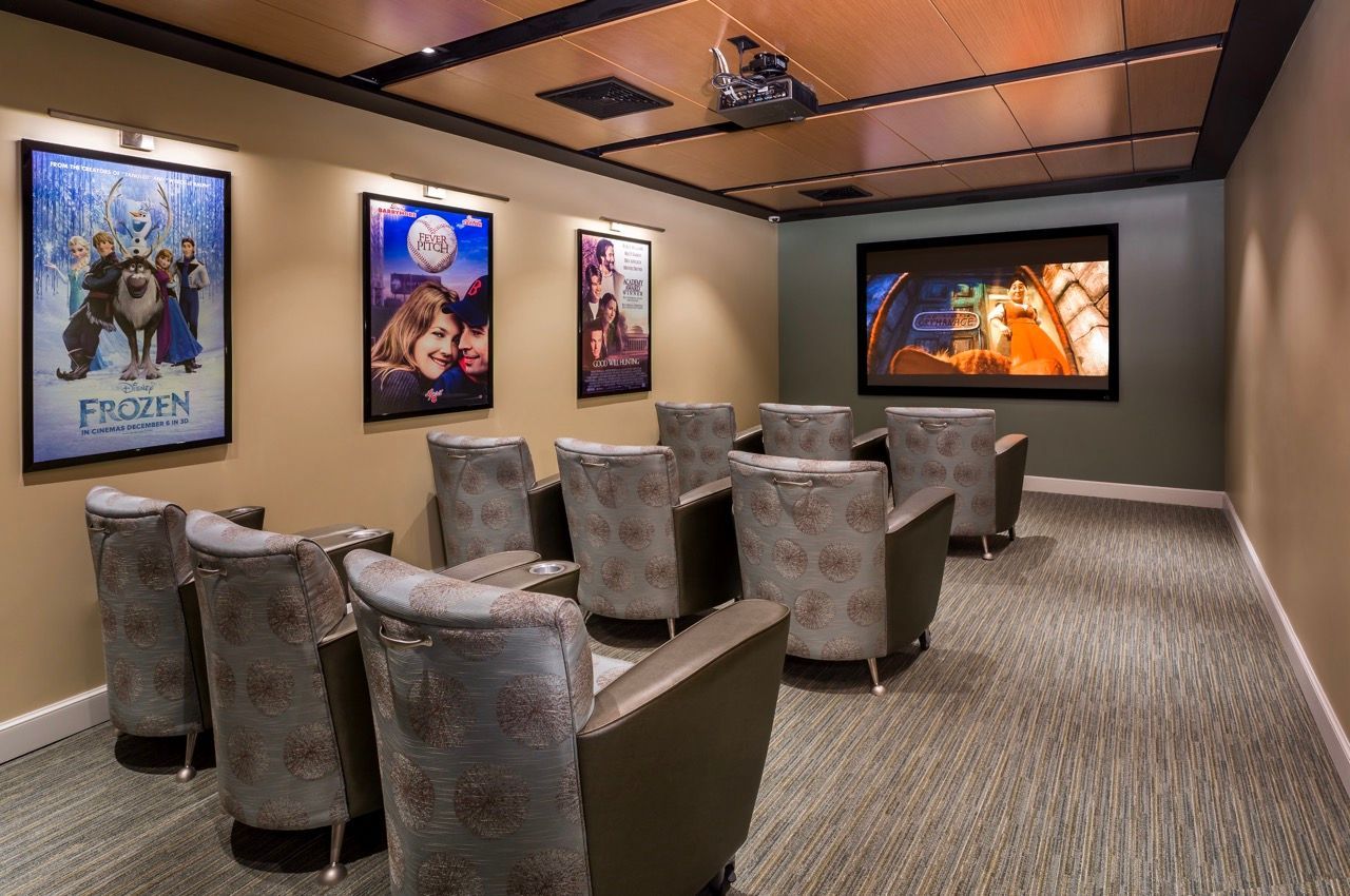 Community movie theater with plush seating and a large screen.